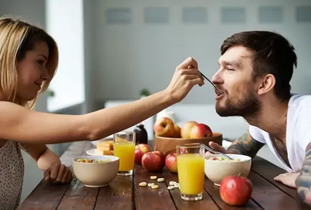 a woman feeds a man nuts to increase potency. 